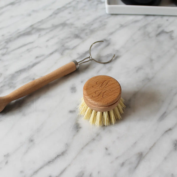 Wooden dish brush with a wooden handle on a marble surface