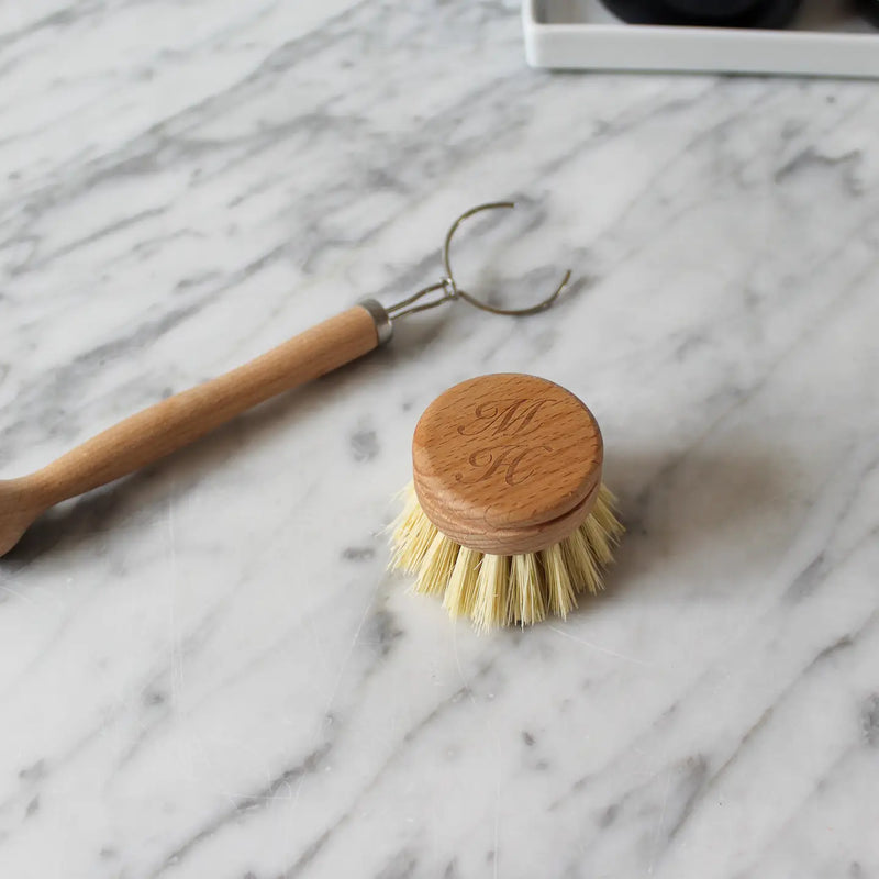 Wooden dish brush with a wooden handle on a marble surface