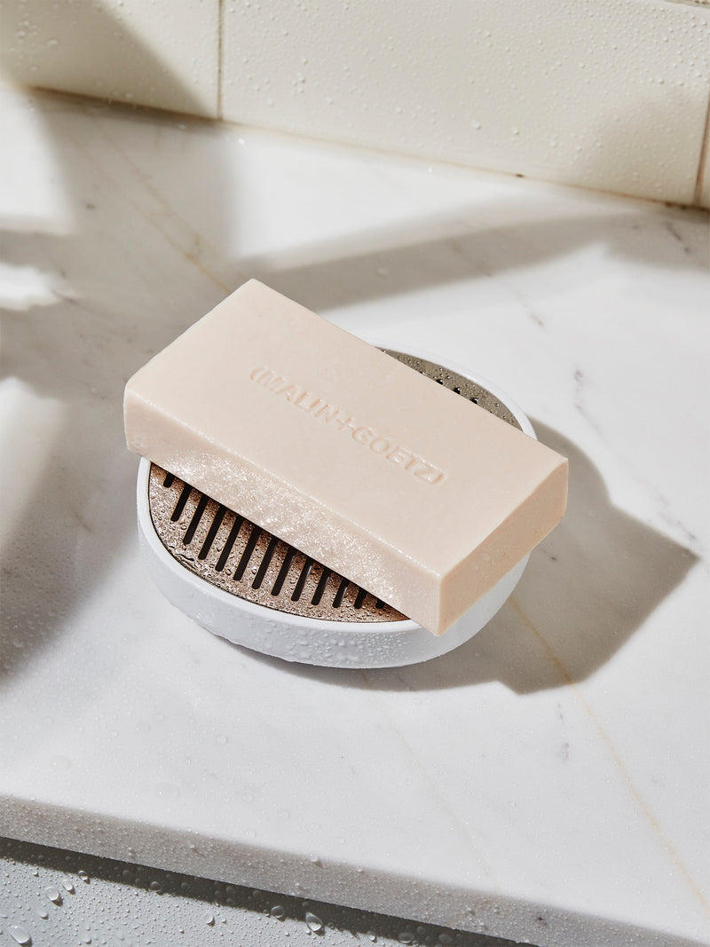 Bar of soap on a white surface with a blurred background